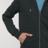 Dettaglio della tasca della felpa nera con zip di Peak Top View, un capo d'abbigliamento che unisce comfort e sostenibilità. Realizzata con materiali riciclati, questa felpa riflette l'impegno del brand verso un futuro eco-friendly. Ideale per chi cerca uno stile casual e responsabile, offre una vestibilità versatile per ogni occasione.